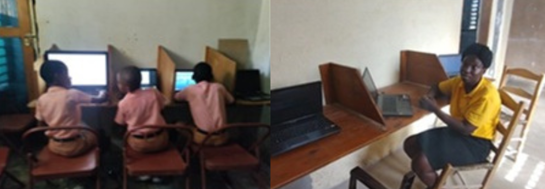 Students learning on computers next to their teacher Ruth.